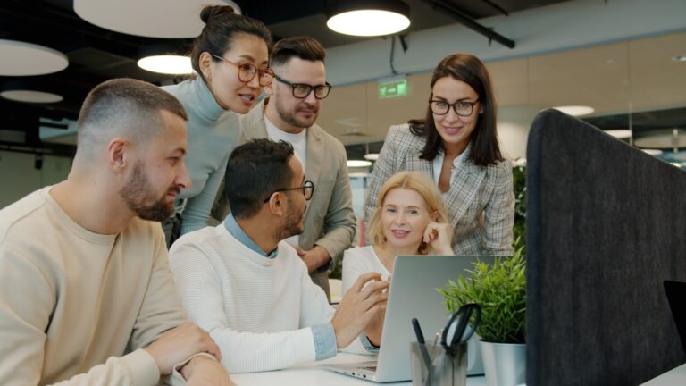 Équipe qui configure un agent IA sur Notion autour d'un ordinateur portable