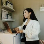 Entrepreneure qui compare ses outils SaaS pour entrepreneurs sur un ordinateur portable