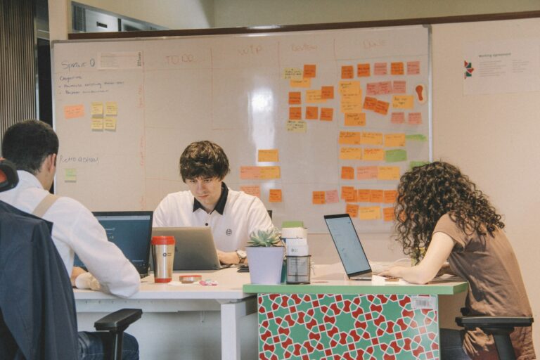 avis ClickUp : équipe qui gère un projet en mode Kanban autour d'un tableau de suivi