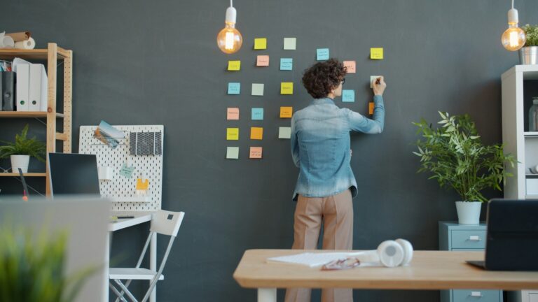 avis Trello : personne qui organise ses tâches sur des notes autocollantes